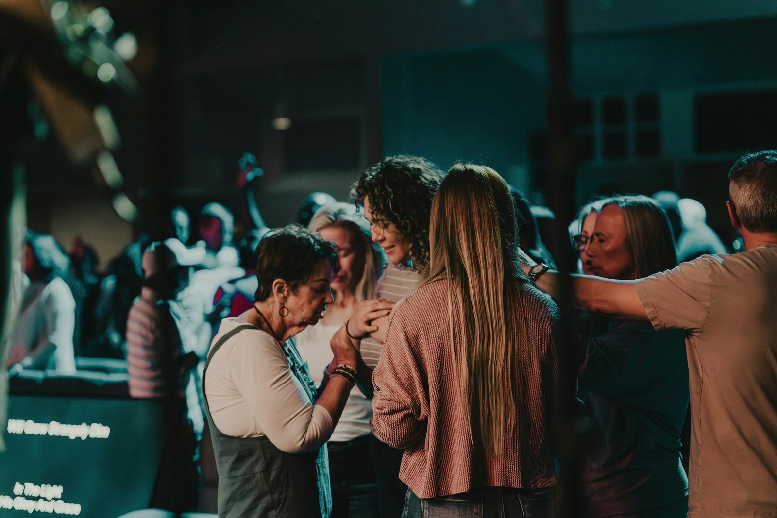 Church members gathered close, praying with one another